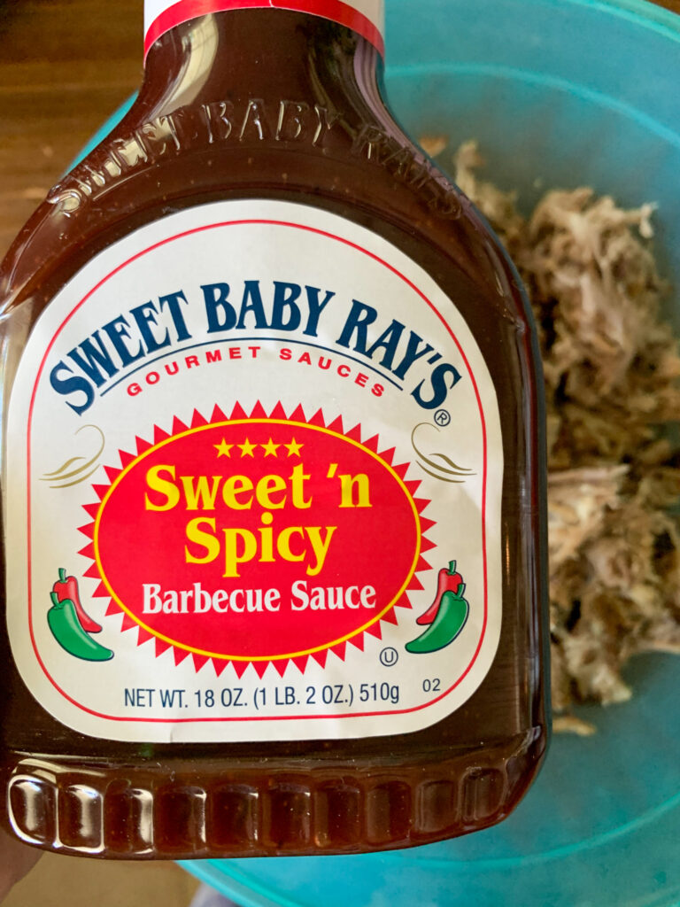Sweet Baby Ray's Sweet 'n Spicy sauce over bowl of smoked meat