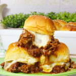 stacked chopped brisket sliders on green plate