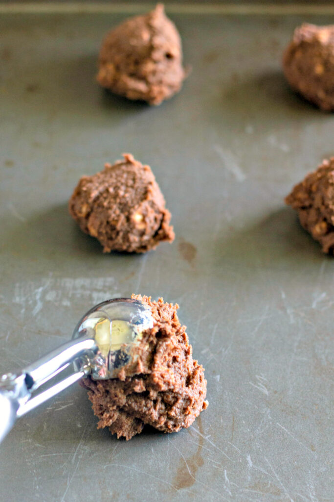 cookie scoop with scoop of dough on baking sheet