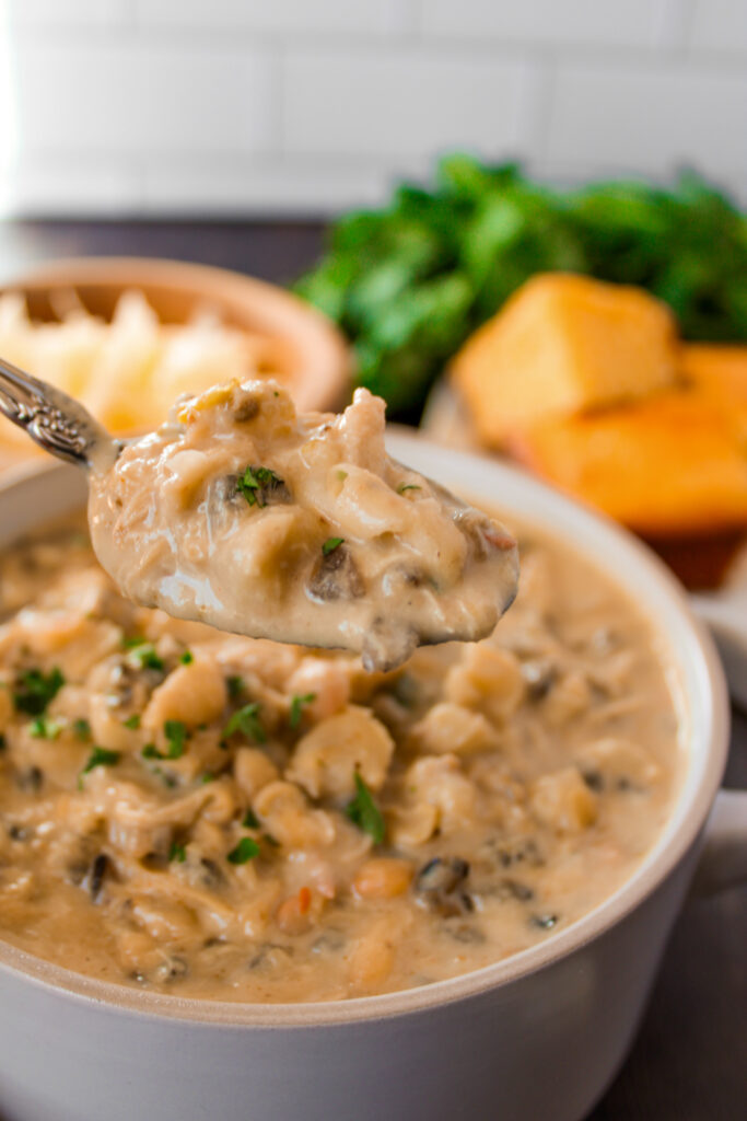 spoonful of creamy chicken and wild rice chili over a bowl