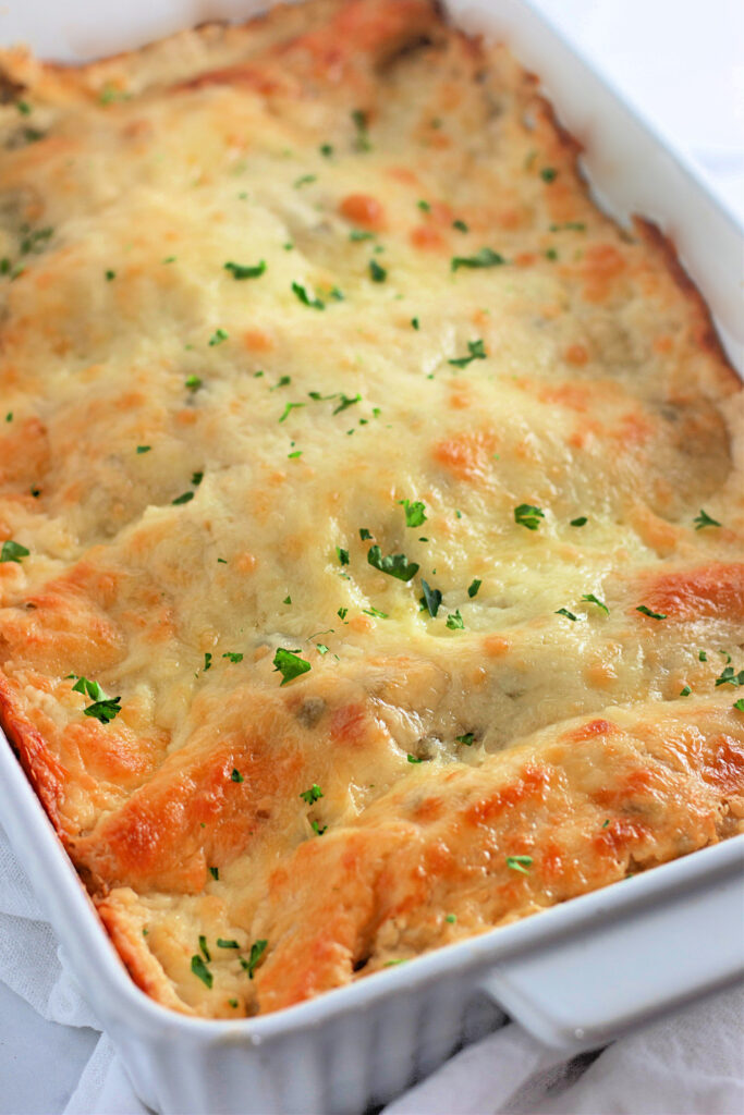 sour cream pulled pork enchiladas with green chiles right out of the oven in pan