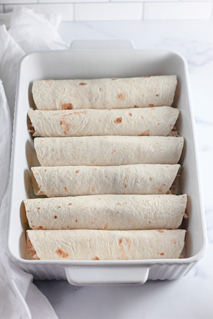 enchiladas rolled up in baking pan during prep