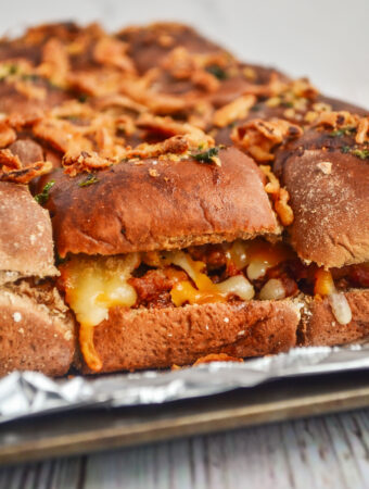 side shot of baked sloppy Joe sliders with Manwich on foil tray