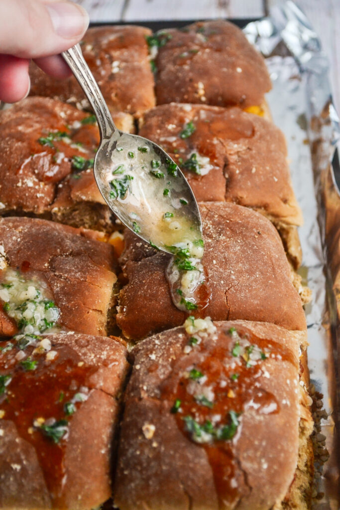 woman drizzles butter sauce rolls