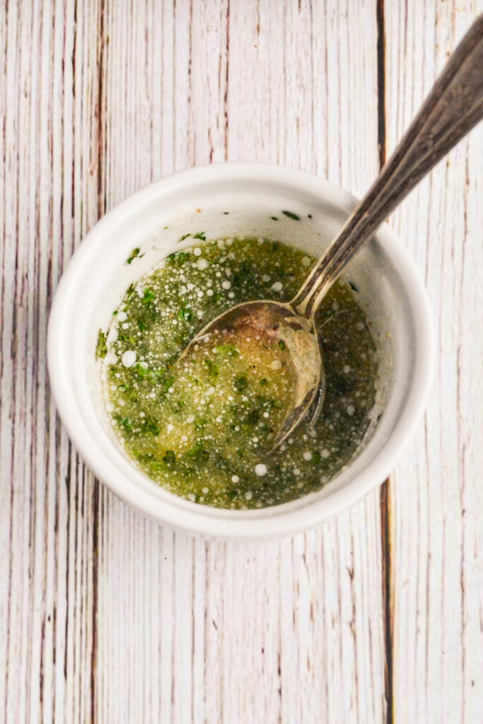 herb butter in white bowl with spoon