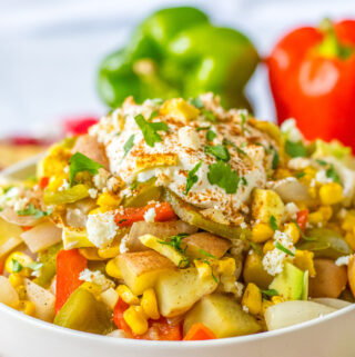 slow cooker Mexican street corn coup with bell peppers at back