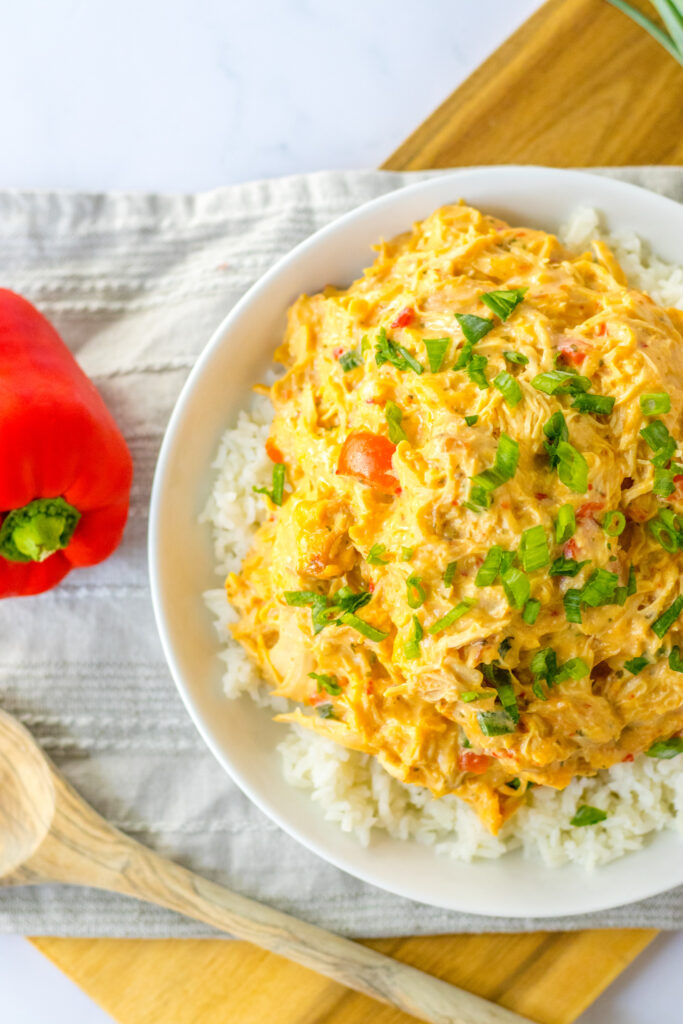 slow cooker sweet chili chicken over rice in overhead shot with red pepper
