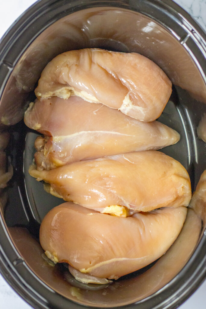 overhead shot of raw chicken breasts in pot