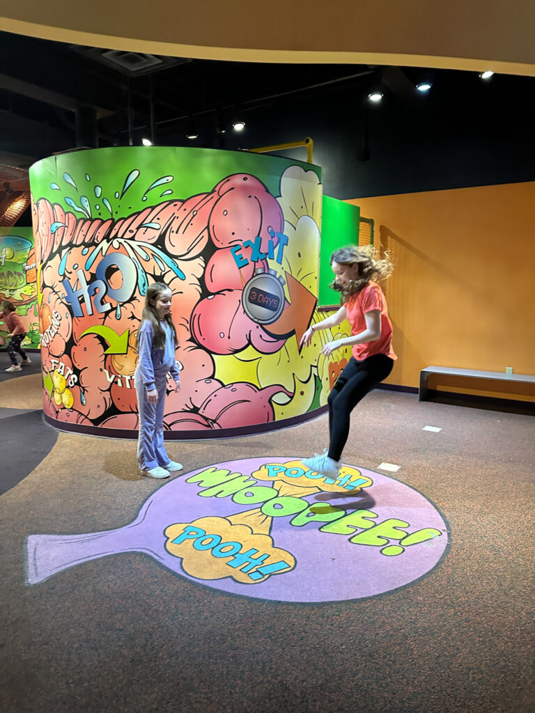 kid Arkansas bloggers, Norah and Harper, jumping on whoopie cushion at Adventure Science Center in Nashville, Tennessee