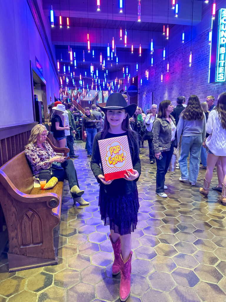 little girl holding popcorn at the Grand Ole Opry