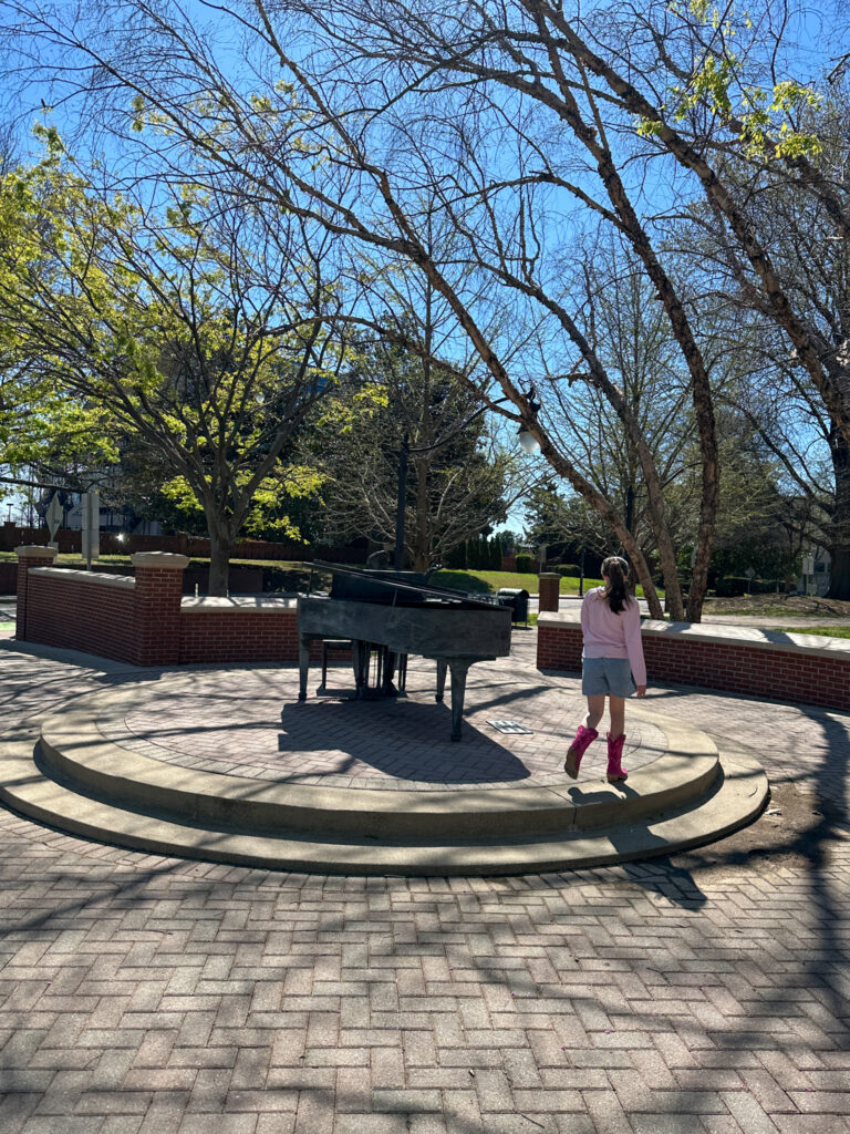 little girl circles the piano man in Music Row during a family Nashville itinerary with kids visit
