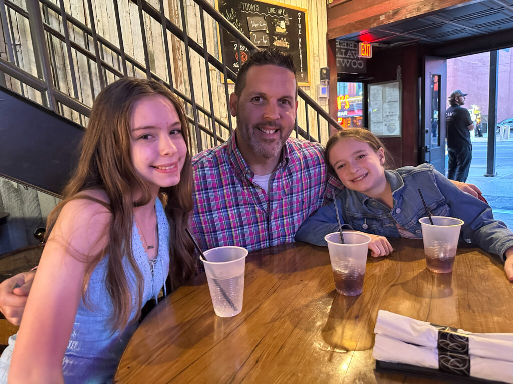 dad and daughters sitting in The Valentine restaurant during kid friendly hours on Broadway in Nashville