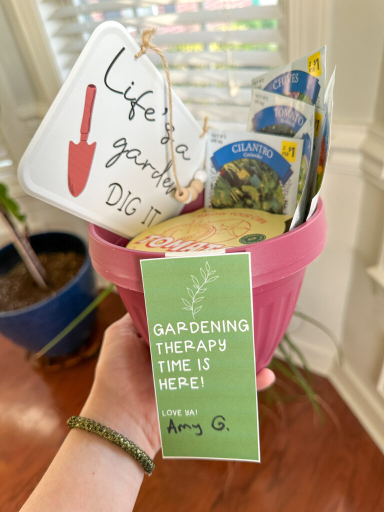 woman holds garden gift basket with free plant gift tag attached in red pot