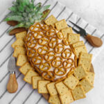 bacon cheddar pineapple cheese ball with cream cheese on a striped napkin