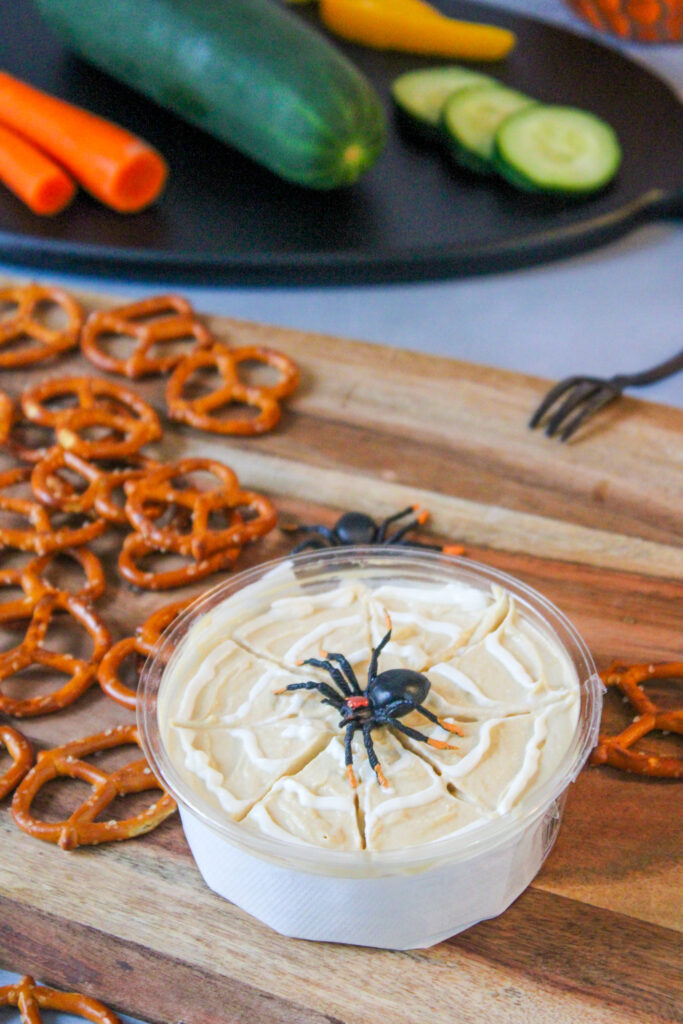 Spiderweb spread hummus for Halloween parties on a charcuterie tray