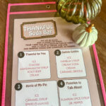 Thanksgiving dirty soda menu on table with decorative pumpkins