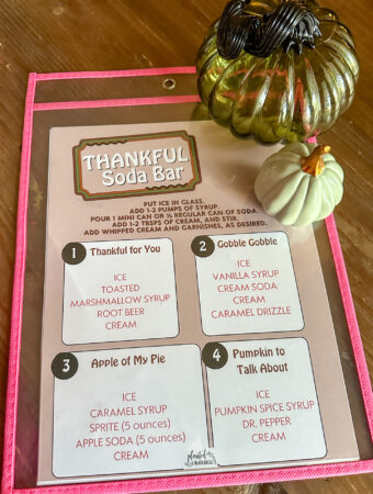 Thanksgiving dirty soda menu on table with decorative pumpkins