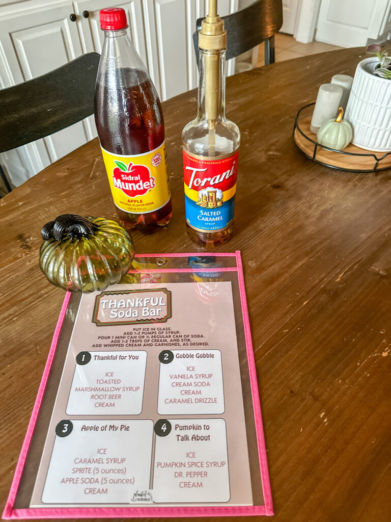 Thanksgiving dirty soda menu on table with bottles of Torani syrup and apple soda