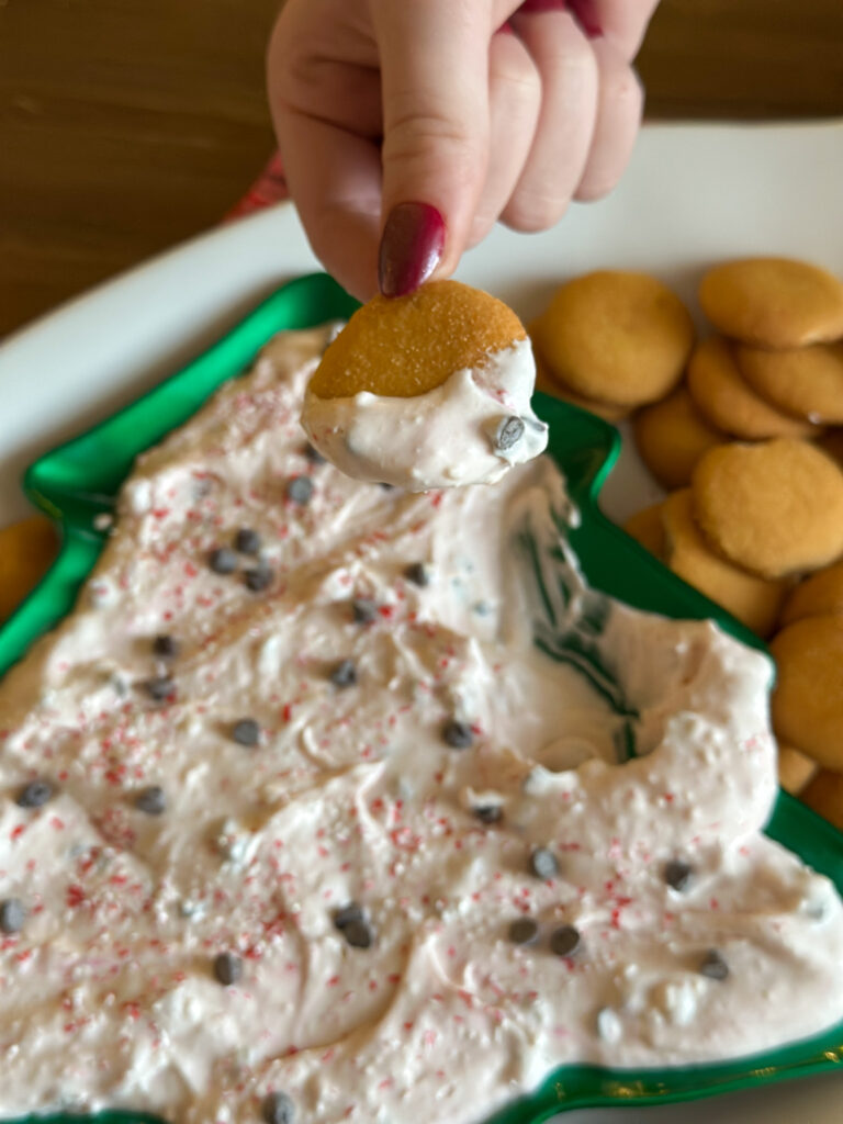 woman scoops cookie into mint chocolate chip cream cheese dip