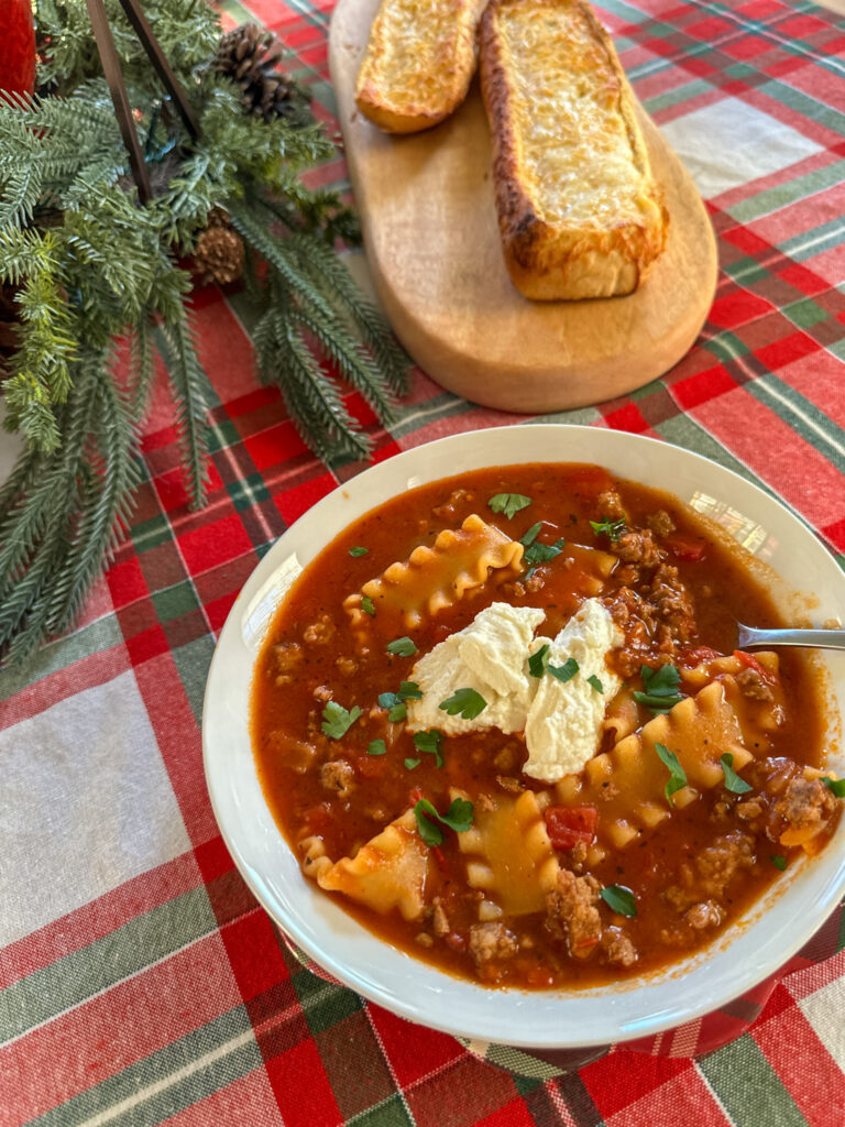 one pot lasagna soup with beef and sausage on a Christmas table with bread