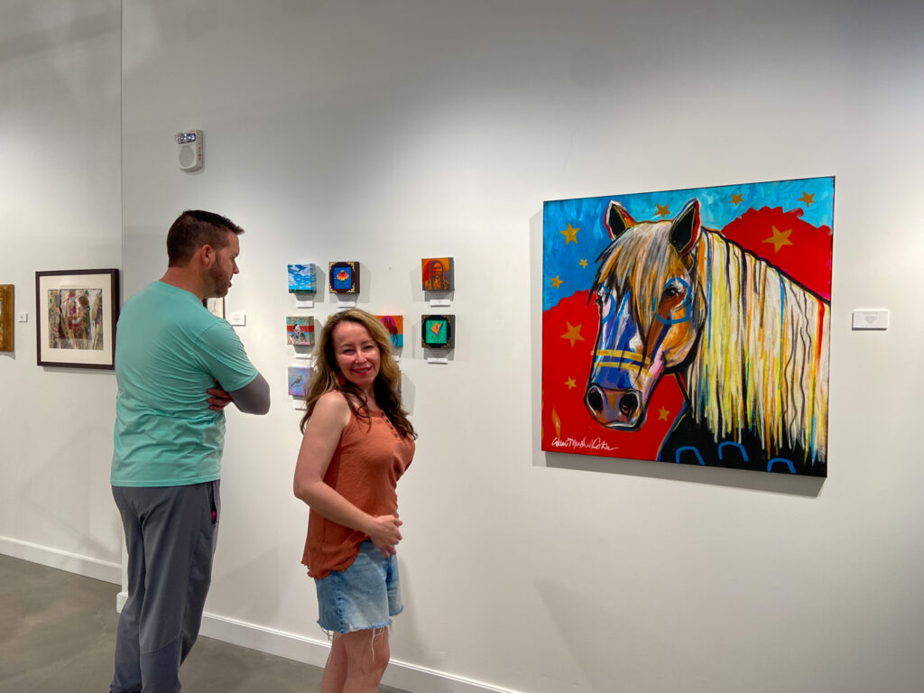 woman checks out Choctaw Art at Exhibit C Gallery in her family travel guide to Okana Resort