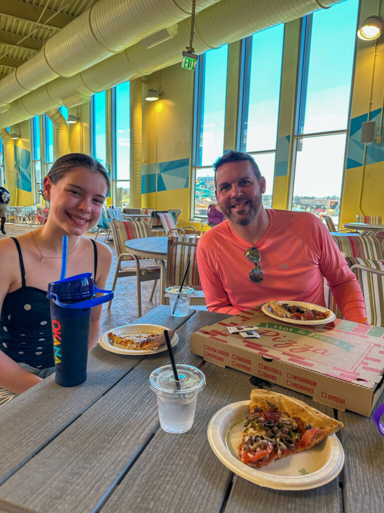 daughter and dad with pizza from Pie Lab for a family travel review of Okana Resort